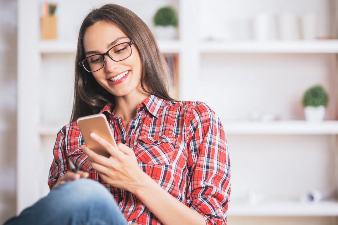 Mujer con gafas mirando el móvil