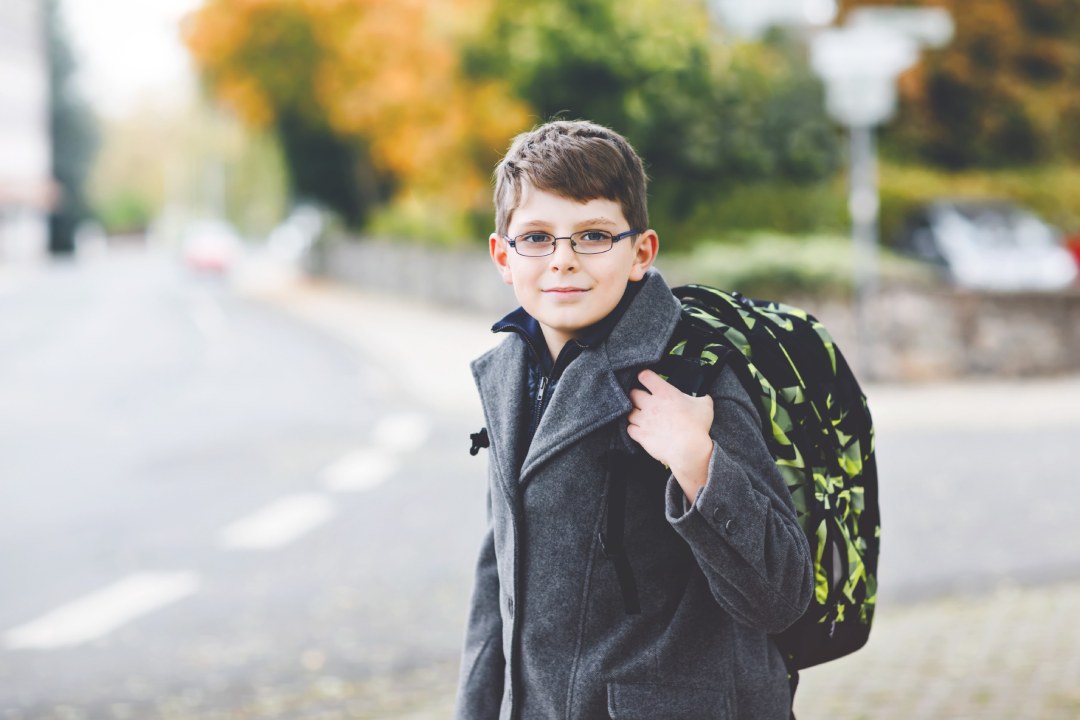 Niño con gafas de miopía que va al colegio
