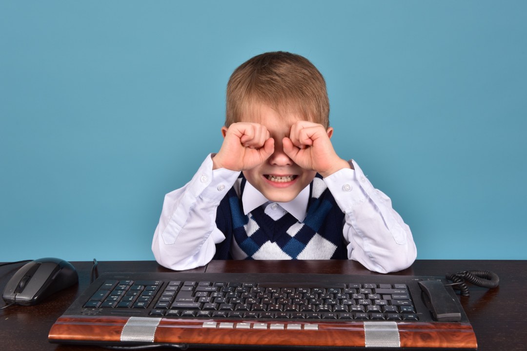 Niño con gafas rodeado de libros